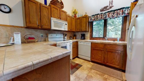 a kitchen with wooden cabinets and a white refrigerator at Meadow Ridge #28 condo in Mammoth Lakes
