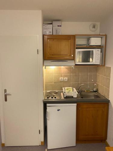 a small kitchen with a sink and a microwave at Studio les toits du Devoluy in Le Dévoluy