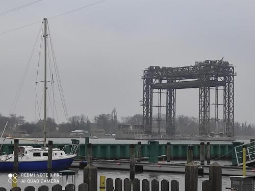 a boat docked at a marina with a large structure at Waldhus in Ueckeritz