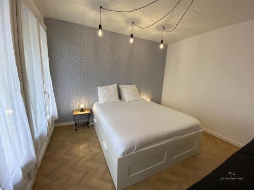 a bedroom with a white bed with lights on it at Espace Cocooning in Chamalières
