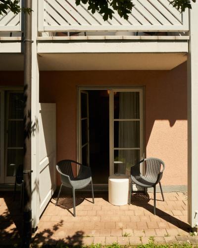two chairs sitting on the porch of a house at Gästehaus am Wasserschloss & Restaurant Wasserschloss Inzlingen in Inzlingen