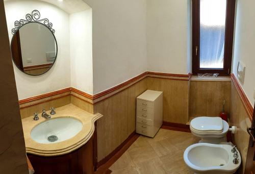 y baño con lavabo, aseo y espejo. en Appartamento Villa Matone, en Grottaferrata