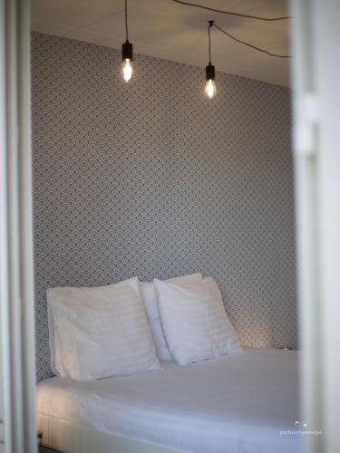 a bed with two pillows and two lights above it at Espace Cocooning in Chamalières