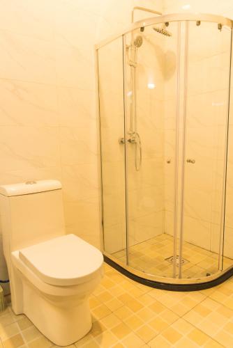 a bathroom with a toilet and a glass shower at AVISHA TOWN HOTEL in Kigali