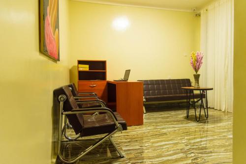 a waiting room with a couch and a table and chairs at AVISHA TOWN HOTEL in Kigali