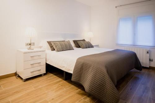 a bedroom with a bed and a dresser and a window at El Niu de Escaldes in Escaldes-Engordany