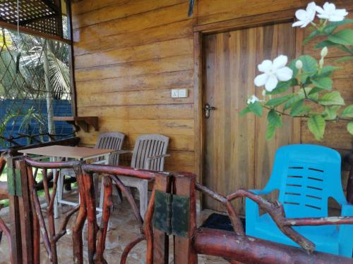 three chairs and a table in front of a cabin at Sea View Resort in Kallady