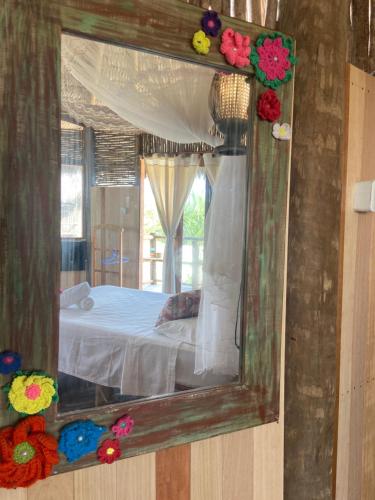 a mirror reflecting a bedroom with a bed in it at Cabanadu Preá Kite in Prea