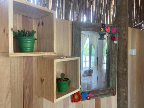 a wooden cabinet with a mirror and a potted plant at Cabanadu Preá Kite in Prea