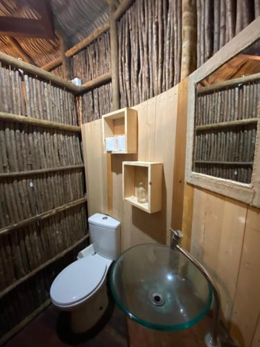 a bathroom with a toilet and a glass sink at Cabanadu Preá Kite in Prea