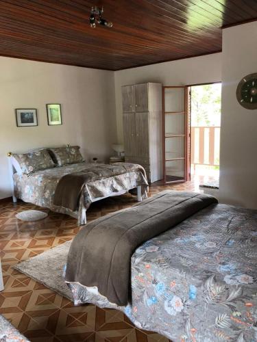 a bedroom with a large bed and a wooden ceiling at Pousada Pedacinho do Ceu- chalé 1 in Cunha