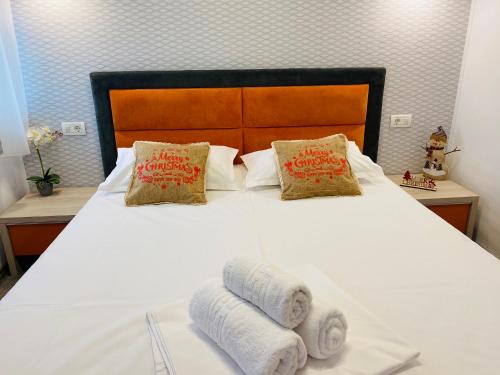 a bedroom with a white bed with towels on it at Orange House Constanta in Constanţa