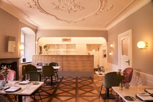 a restaurant with tables and chairs and a kitchen at Gästehaus am Wasserschloss & Restaurant Wasserschloss Inzlingen in Inzlingen