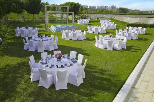 a group of white tables and chairs on the grass at Park Rotana Abu Dhabi in Abu Dhabi