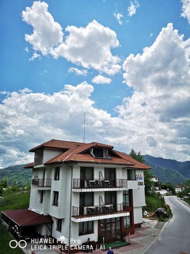 a building with balconies on the side of a road at Ribkata Family Hotel in Smolyan