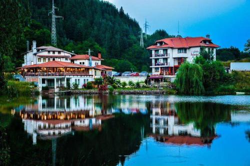 a group of buildings next to a body of water at Ribkata Family Hotel in Smolyan