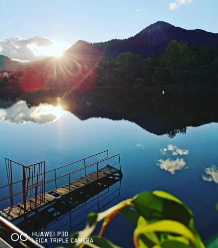 a view of a lake with the sun reflecting on it at Ribkata Family Hotel in Smolyan