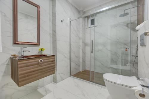 a bathroom with a shower and a toilet and a sink at Sapanca View Hotel in Sapanca