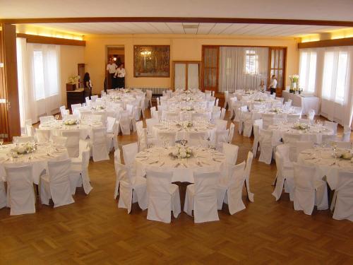 un salón de banquetes con mesas blancas y sillas blancas en Gasthof Schmölz en Sankt Christophen