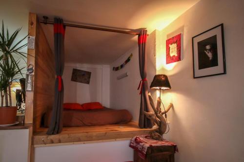 ein Schlafzimmer mit einem Himmelbett in einem Zimmer in der Unterkunft Calm studio in the historical centre - Dodo et Tartine in Guillestre