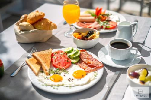 a table topped with plates of breakfast foods and coffee at May Beach Hotel in Rethymno Town