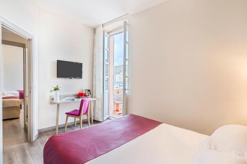 a bedroom with a bed and a desk with a chair at Best Western Hotel du Roy d'Aragon in Bonifacio