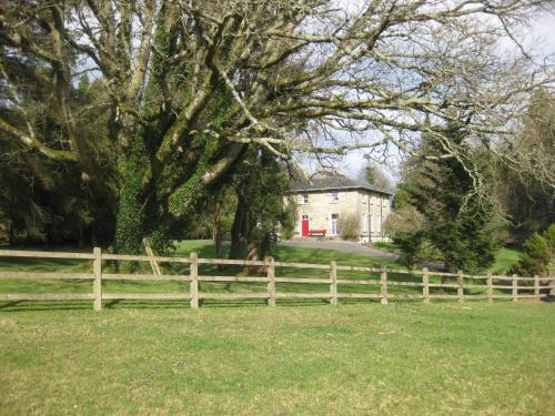 a wooden fence in front of a house with a tree at Glebe House in Mohill