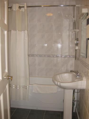 a bathroom with a tub and a sink and a shower at Glebe House in Mohill