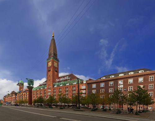 un gran edificio de ladrillo rojo con una torre de reloj en Scandic Palace Hotel, en Copenhague