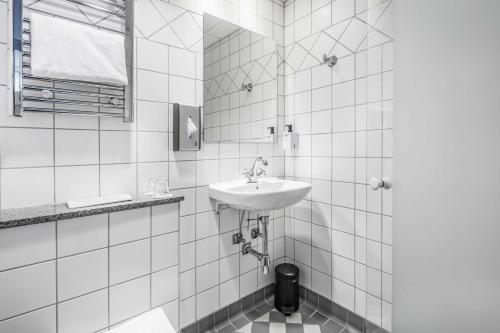 a white bathroom with a sink and a toilet at Scandic Webers in Copenhagen