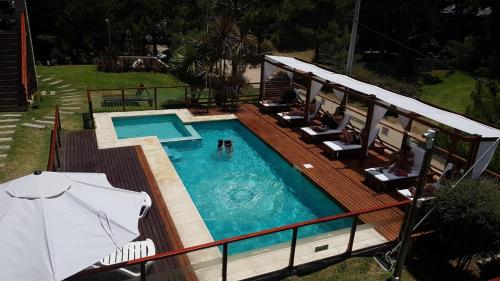 una piscina con sillas y sombrilla en Arena de Mar Dpto B en Las Gaviotas