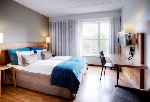 a bedroom with a bed and a desk and a television at Scandic Silkeborg in Silkeborg