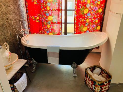 a bath tub in a bathroom with a red shower curtain at Techas City Center Luxurious Suite in Praia