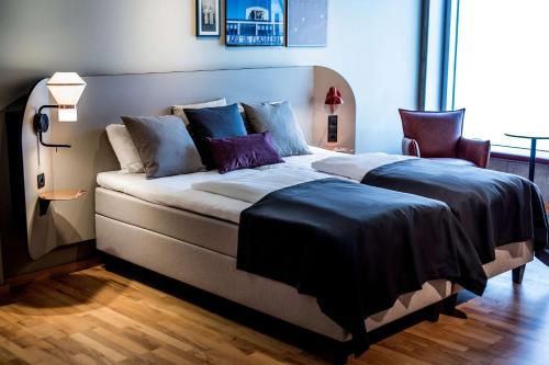 una camera da letto con un grande letto con cuscini viola di Scandic Kødbyen a Copenaghen