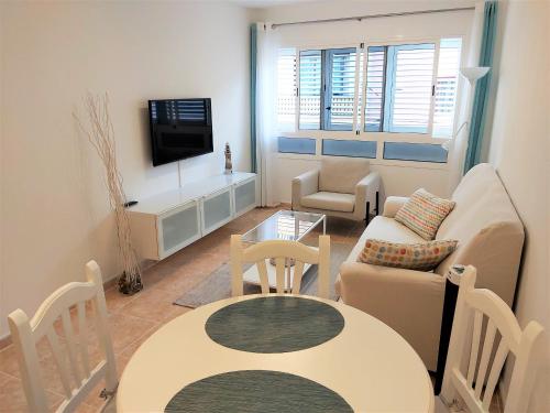 uma sala de estar com um sofá e uma mesa em Apartamentos Sarah em Morro del Jable