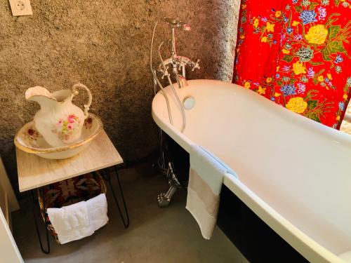 a bathroom with a bath tub and a vase on a table at Techas City Center Luxurious Suite in Praia
