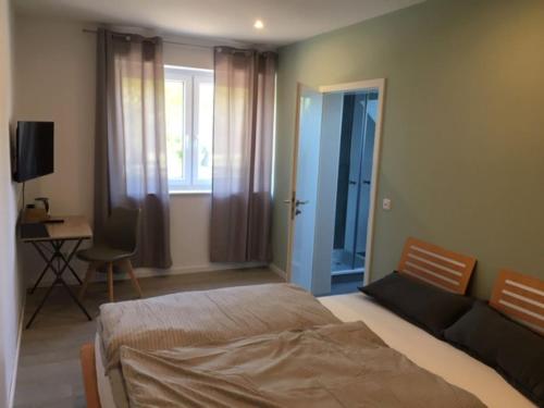 a bedroom with a bed and a desk and a window at Gäste und Messezimmer Adelheidsdorf in Celle