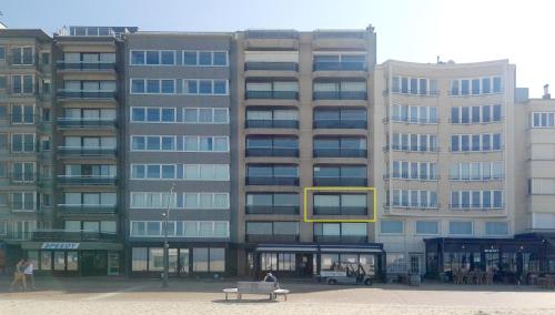 a large building with a yellow window in front of it at Oostduinkerke Apartments in Oostduinkerke