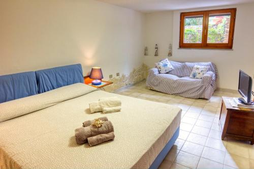 een slaapkamer met een groot bed en een bank bij Domus De Martina in Stintino