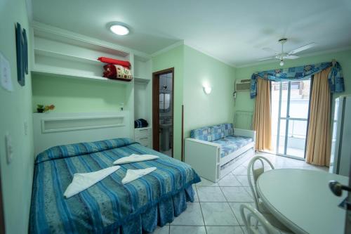 a bedroom with a bed and a table in it at Pousada Cantinho Sonhado in Bombinhas