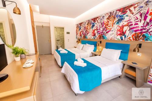 a hotel room with two beds and a desk at May Beach Hotel in Rethymno Town