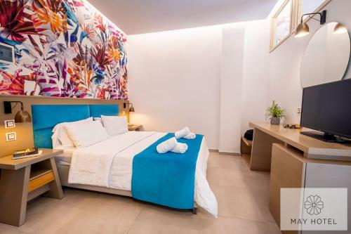 a hotel room with a bed and a tv at May Beach Hotel in Rethymno Town