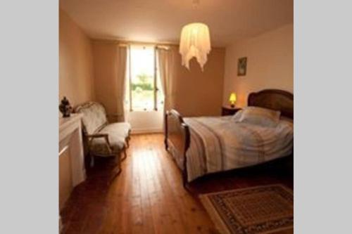 ein Schlafzimmer mit einem Bett, einem Stuhl und einem Fenster in der Unterkunft la ferme, Coeur De Combray in Ernes