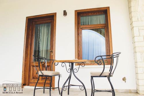 a table and two chairs in front of a window at KERCULLA Resort in Gjirokastër