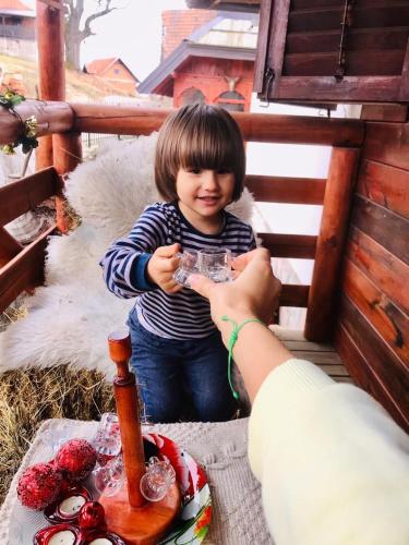 a little girl sitting next to a table with a cake at Holiday Home Captain's Village in Šljivovica