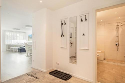 a white bathroom with a shower and a mirror at Ferienwohnung Gartenstraße in Lindau-Bodolz