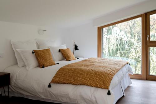 a bedroom with a large bed with a large window at La villa M Évian in Publier