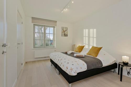 une chambre avec un lit et une fenêtre dans l'établissement Villa Josephine, à Coxyde