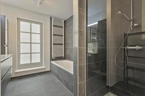 une salle de bain avec une douche, une baignoire et un lavabo dans l'établissement Villa Josephine, à Coxyde