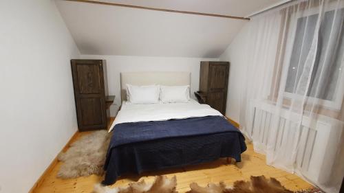 a bedroom with a bed in a white room at Bran 99 in Bran